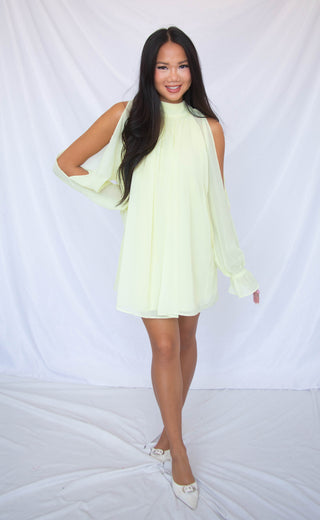 Woman wearing a light yellow dress against a white background