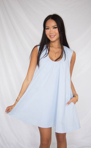 Woman wearing a light blue dress against a white background