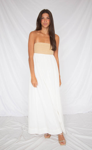 Woman wearing a two-tone dress with beige top and white skirt on a white background