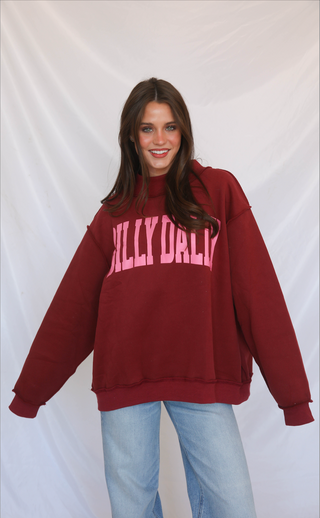 Person wearing a maroon mock neck sweatshirt with 'DILLY DALLY' text against a white background