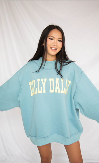 Person wearing a light blue sweatshirt with 'DILLY DALLY' text on a white background